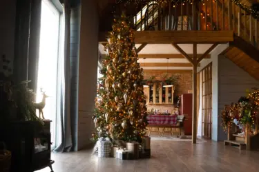 Pencil christmas tree in entry way, as tall as the first floor, decorated with red and gold decorations